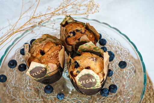 "Een smakelijke gemengde bessenmuffin gevuld met rode bessen, zwarte bessen en blauwe bessen, met een vulling van blauwe bessenjam en een kruimelige topping."