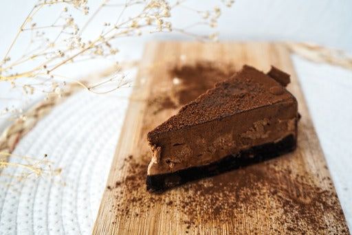 Een close-up van een Bavaroise punt omhuld met zachte chocolade, met een glanzende afwerking. De punt straalt luxe uit met zijn rijke chocoladesmaken en verfijnde textuur, perfect voor fijnproevers van chocolade.