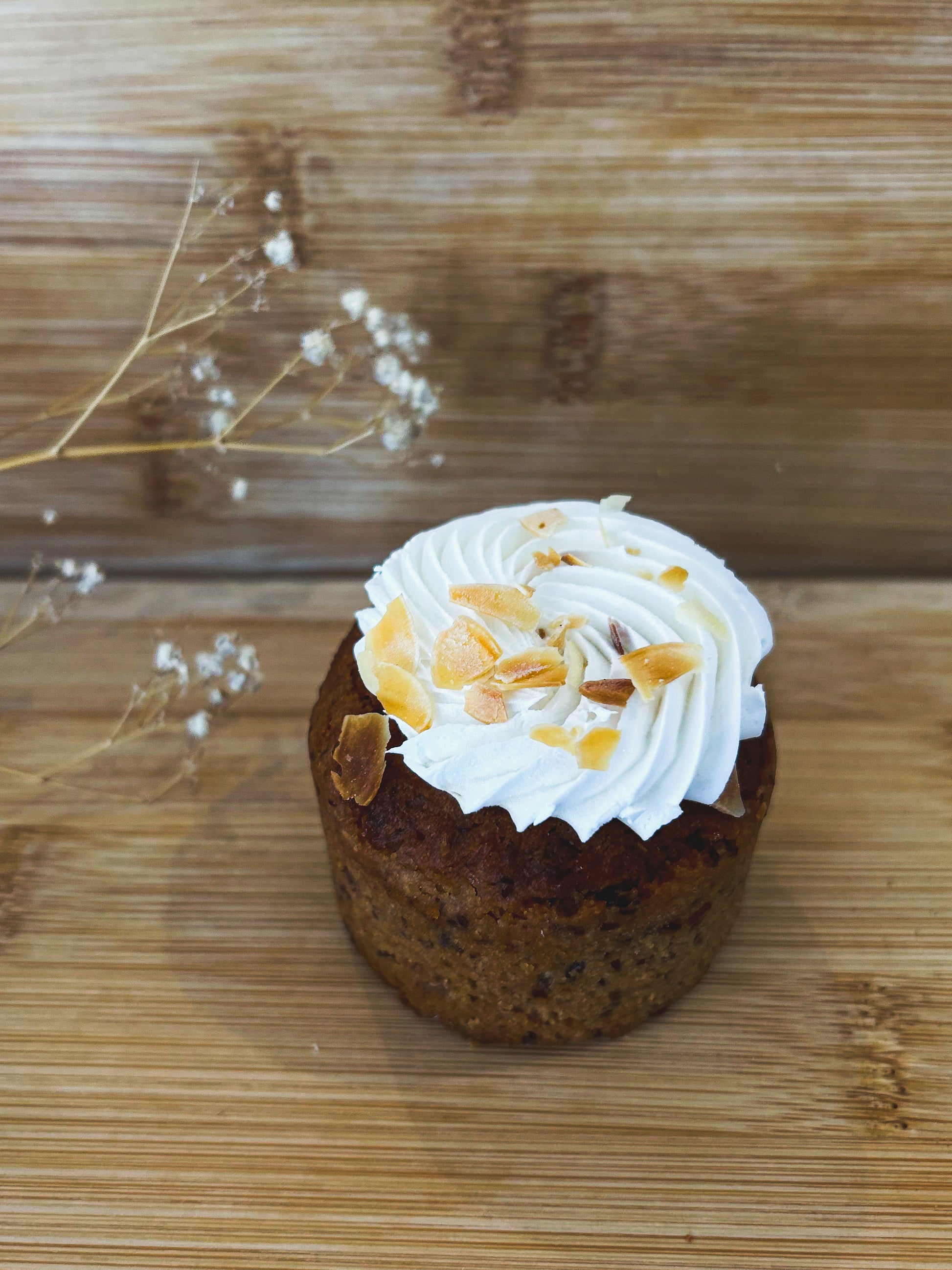  "Een prachtig gepresenteerde glutenvrije carrot cake bedekt met romige frosting, versierd met geraspte wortelen en een vleugje kaneel."