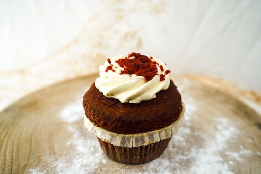 "Een close-upbeeld van een heerlijke Vegan Red Velvet Cupcake met romige veganistische roomkaas frosting, perfect voor een feestelijke traktatie."