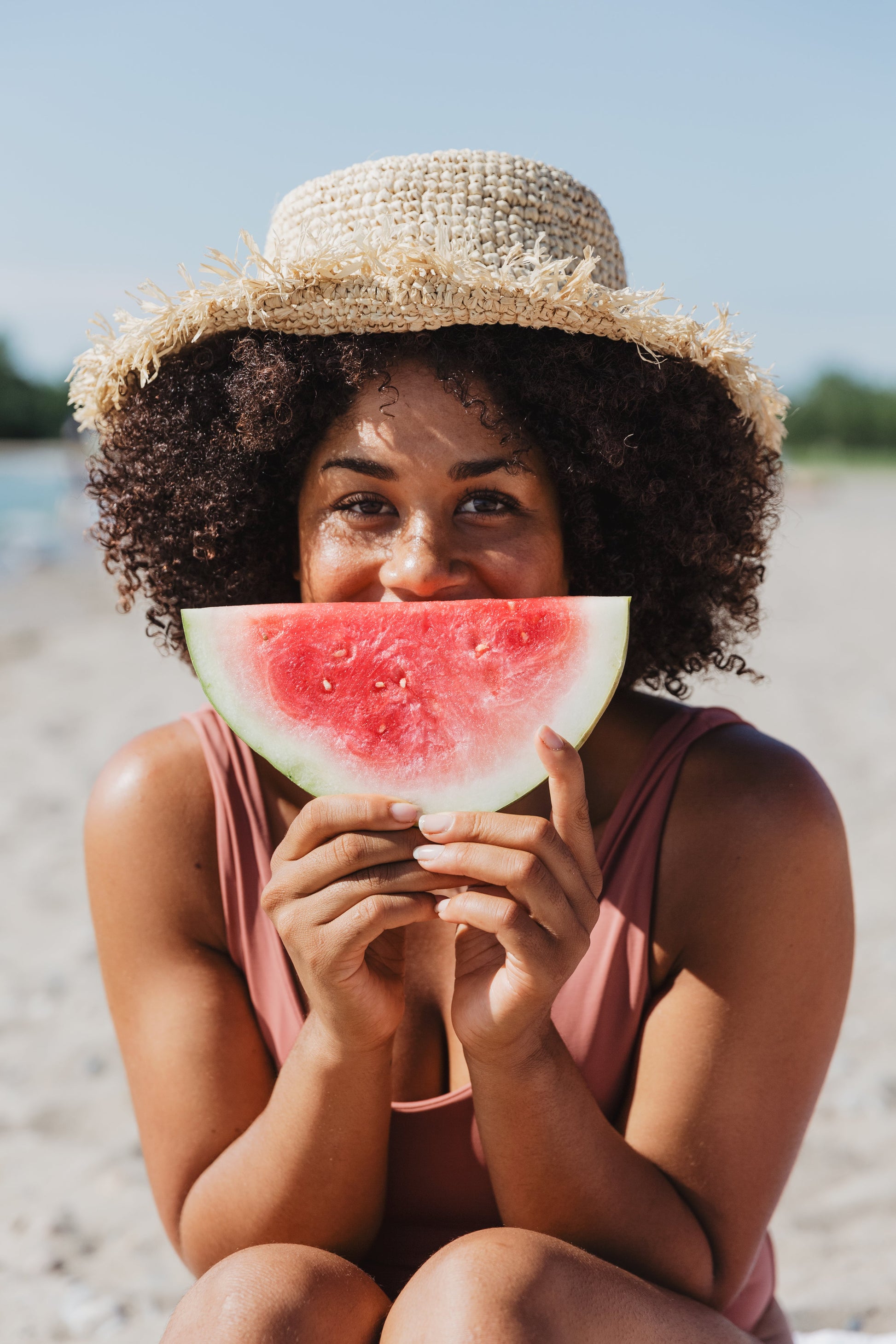 "Jonge vrouw geniet van een stuk watermeloen na een detox-ervaring van The Vegan Saint."